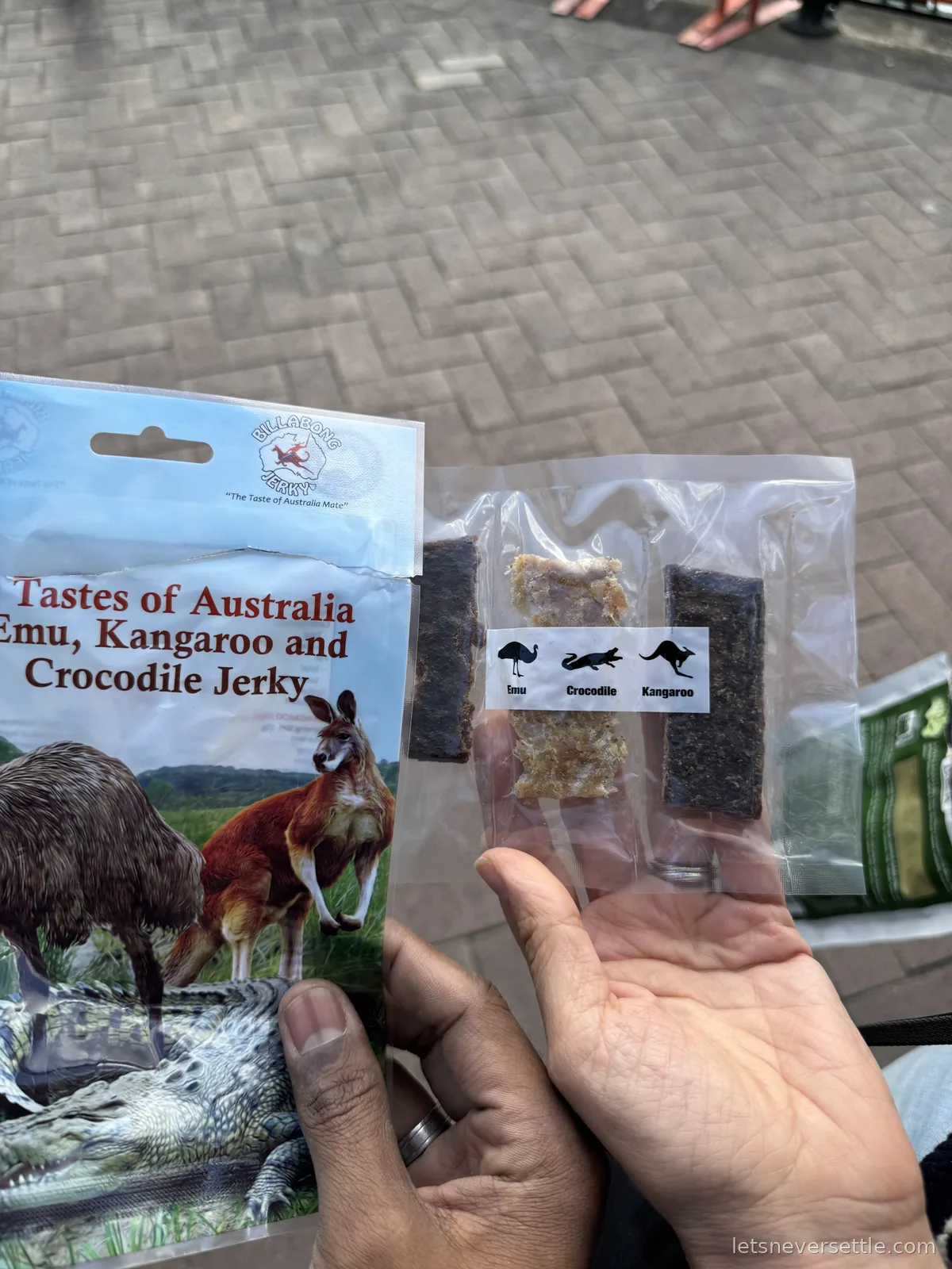 A Tastes of Australia sampler pack held in hand with labelled strips of emu, crocodile and kangaroo jerky