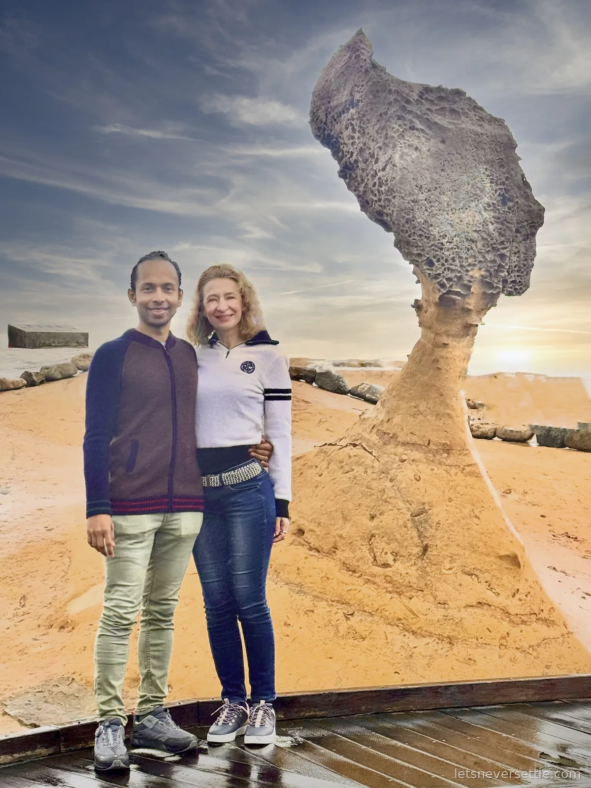 Inga and Dileep beside the mushroom-shaped Queen's Head rock at Yehliu Geopark, the sea glowing behind at sunset