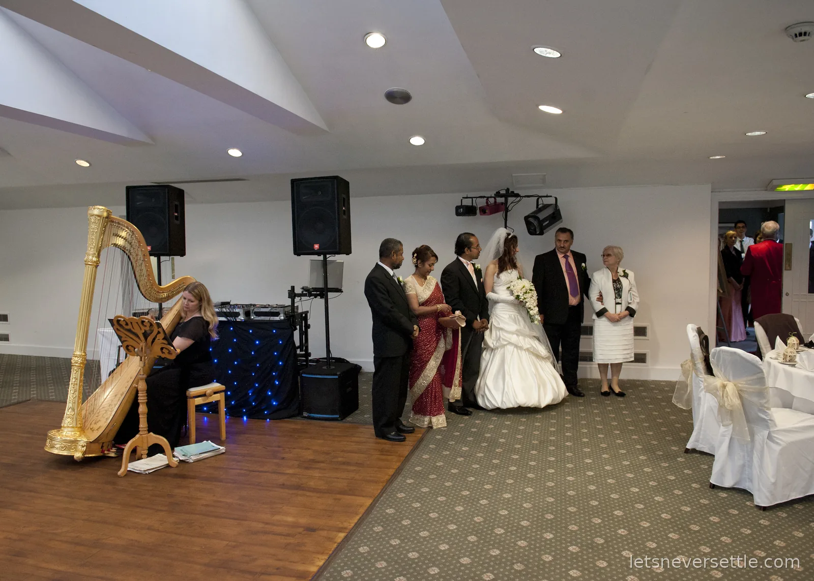 The reception room with the harpist playing a gilded harp while Inga and Dileep greet their parents and guests by the dance floor