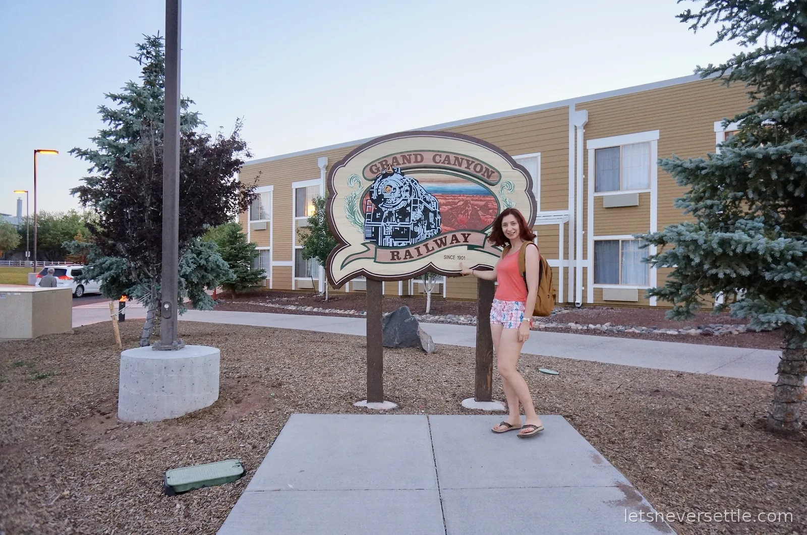 Inga posing beside the Grand Canyon Railway hotel sign with a steam engine painted on it