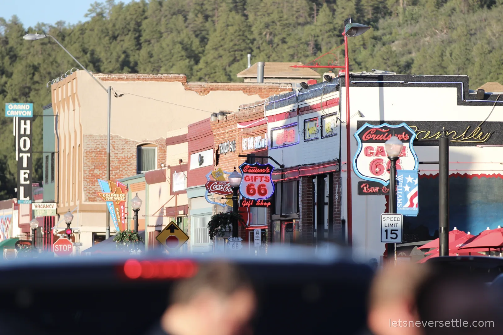 Telephoto view down the main street of Williams, Arizona, crowded with vintage signs including the Grand Canyon Hotel and Cruiser's Cafe 66