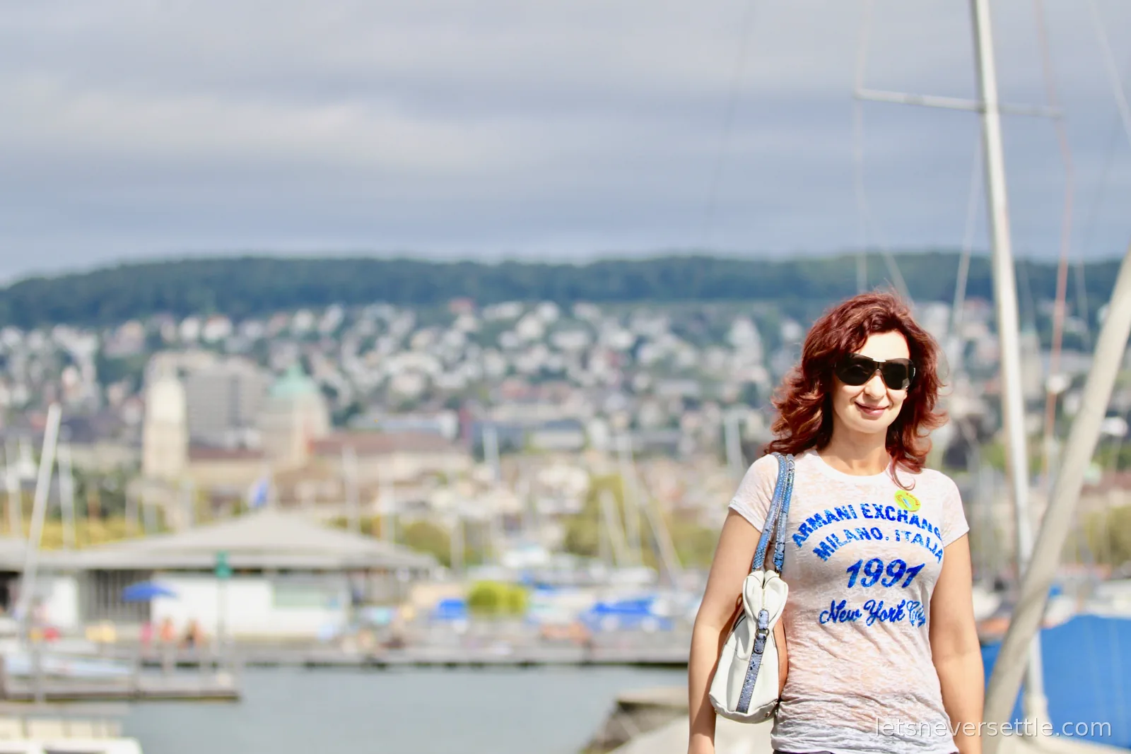 Inga at the lakeside marina with sailboat masts and the hillside houses of Zurich blurred behind